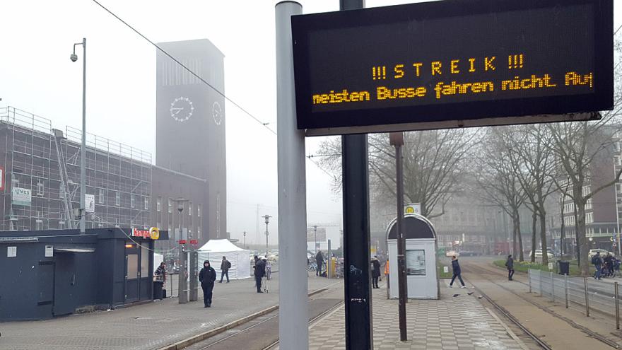 Straßenbahnhaltestelle mit digitalem Hinweisschild: "STREIK!"